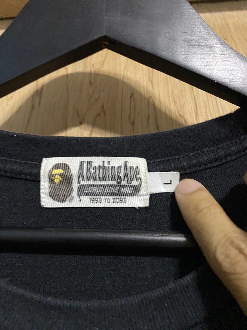 A Bathing Ape BAPE DSMG Pocket Tee (Category: Tshirts & Polo Shirts ) located in Manila. Submitted by callejage69430 (Listing ID 1460804570, Image 3). Description: 21 width 29 Length - Black A Bathing Ape (BAPE) T-shirt - Size: Large (L) - Left chest pocket with embroidered ape head logo - Yellow embroidered 'DSMG BAPE' speech bubble graphic above pocket - Ideal for streetwear fashion.