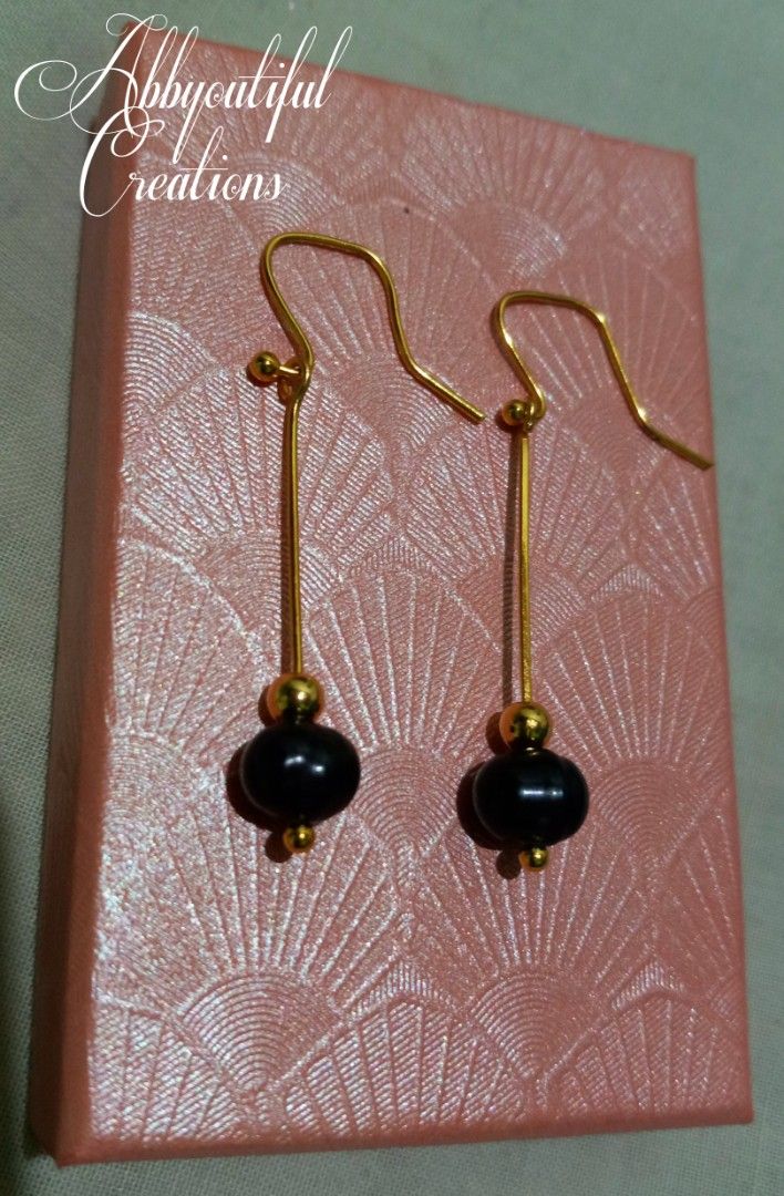 Abbyoutiful Creations Gold Dangle Earrings with Black Beads (Category: Earrings) located in Dasmarinas. Submitted by abbyoutique_online (Listing ID 1460880479, Image 2). Description: • Code: E17 • Elegant gold dangle earrings with black beads • Simple and chic design • Hangs from secure gold hooks • Adds a touch of flair to any outfit • Versatile for everyday wear or special occasions • Handmade with ❤️ • Comes with pink gift box • Materials are 