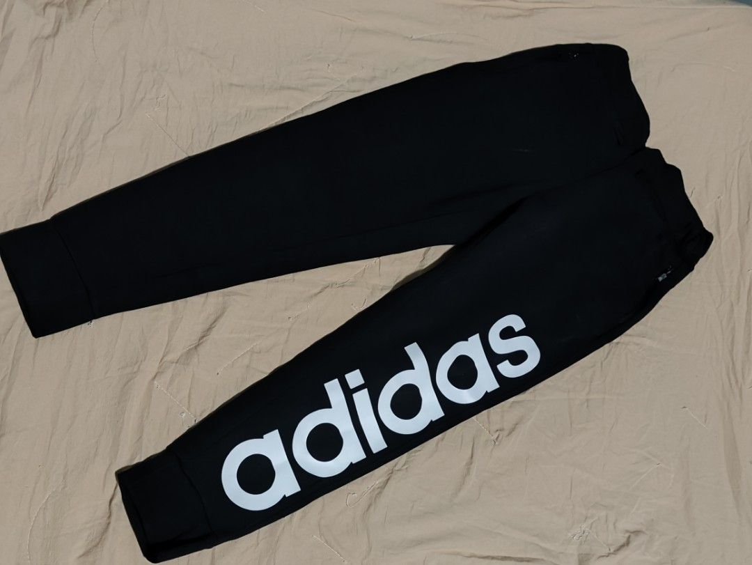 Adidas Black Joggers with Large Logo (Category: Joggers) located in Lucena. Submitted by cha_riz010726 (Listing ID 1460899897, Image 2). Description: - Classic black Adidas joggers - White Adidas logo on the side leg - Elastic waistband with adjustable drawstring - Cuffed ankles for a snug fit - Versatile for casual wear or athletic activities.
