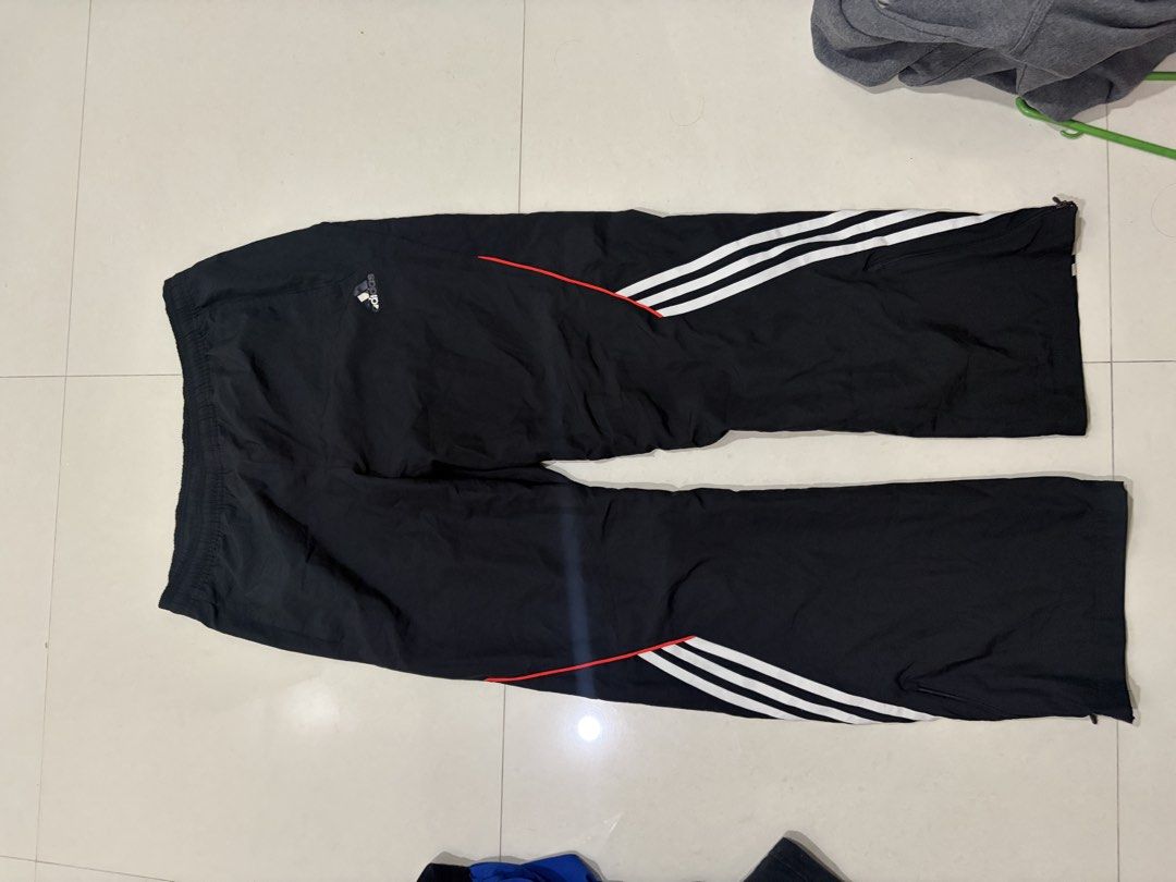 Adidas Black Track Pants with White Stripes (Category: Joggers) located in Marilao. Submitted by astroman.22 (Listing ID 1460887770, Image 1). Description: - Classic black Adidas track pants - Features iconic three white stripes with a red accent line - Comfortable elastic waistband - Zippers at the ankle for adjustable fit - Perfect for athletic activities or everyday casual wear.