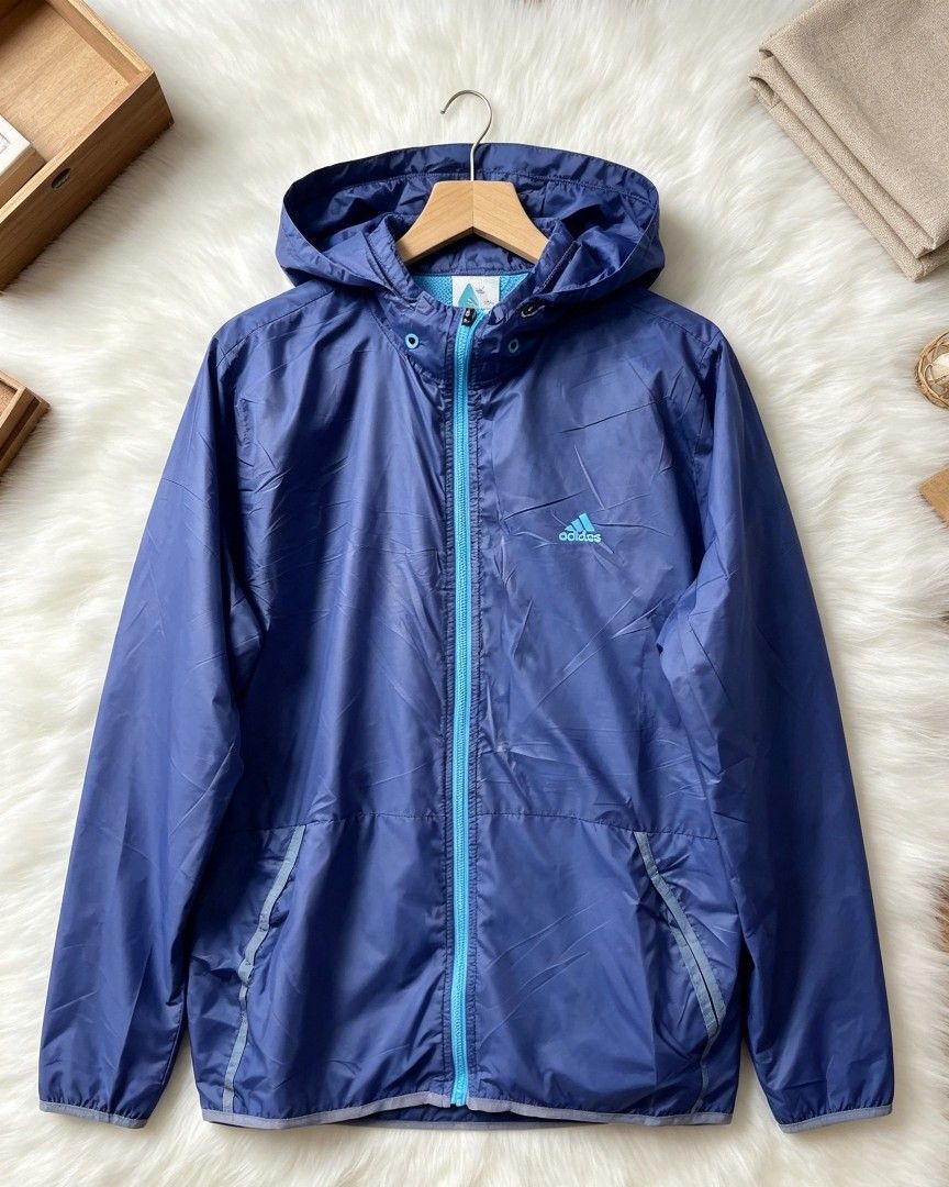 Adidas Lightweight Hooded Windbreaker Jacket Blue (Category: Coats, Jackets and Outerwear) located in Manila. Submitted by momofunodos (Listing ID 1460831697, Image 1). Description: - Blue Adidas windbreaker jacket - Features a hood - Full zip front closure - Two side pockets - Lightweight and packable design - Ideal for outdoor activities - Contrasting light blue zipper and hood lining - Adidas logo prominently displayed on the chest Note! buy a