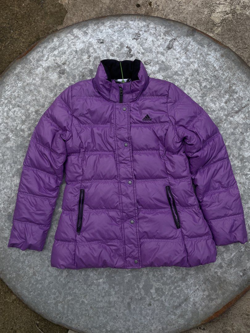Adidas Purple Puffer Jacket with Hood (Category: Coats, Jackets and Outerwear) located in Manila. Submitted by saintino0222 (Listing ID 1460887472, Image 1). Description: - Purple Adidas puffer jacket - Full zip front with snap closures - Two zip pockets - Hood with classic Adidas stripes - Ideal for staying warm and stylish.