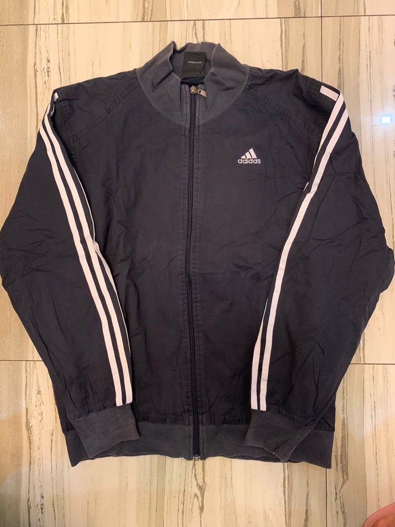 Adidas Track Jacket with 3 Stripes (Category: Coats, Jackets and Outerwear) located in Manila. Submitted by vintaurafindsco. (Listing ID 1460883225, Image 1). Description: - Classic Adidas track jacket - Iconic three stripes on sleeves - Zip-up front - Ribbed collar and cuffs - Dark navy color - Ideal for casual wear or sports.
