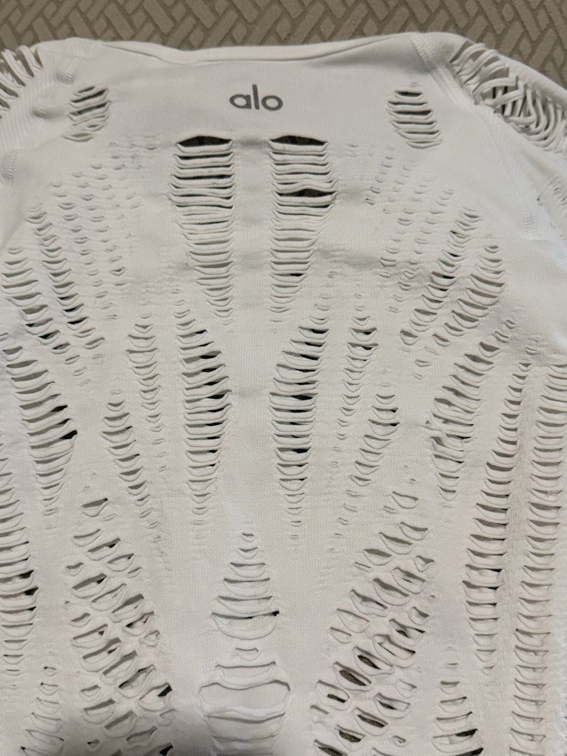 Alo White Distressed Long Sleeve Top Size S (Category: Activewear) located in Caloocan City. Submitted by miutasha888 (Listing ID 1460810547, Image 3). Description: - Brand: Alo - Color: White - Style: Long sleeve top - Design: Distressed, ripped all over - Material: Polyester and Spandex - Size: S - Origin: Made in Turkey - Perfect for layering or as a statement piece.