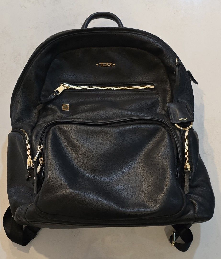 Authentic Tumi Voyageur Halle Backpack (Category: Luxury Bags & Wallets) located in Quezon City. Submitted by kdjfuroe (Listing ID 1460751387, Image 1). Description: ✔️Genuine leather exterior with gold hardware ✔️Front zip pocket + main U-zip compartment ✔️Padded interior laptop sleeve Adjustable padded shoulder straps ✔️Top carry handle ✔️Interior organizer pockets Condition: Preloved, well taken care of — leather remains soft with no major scr