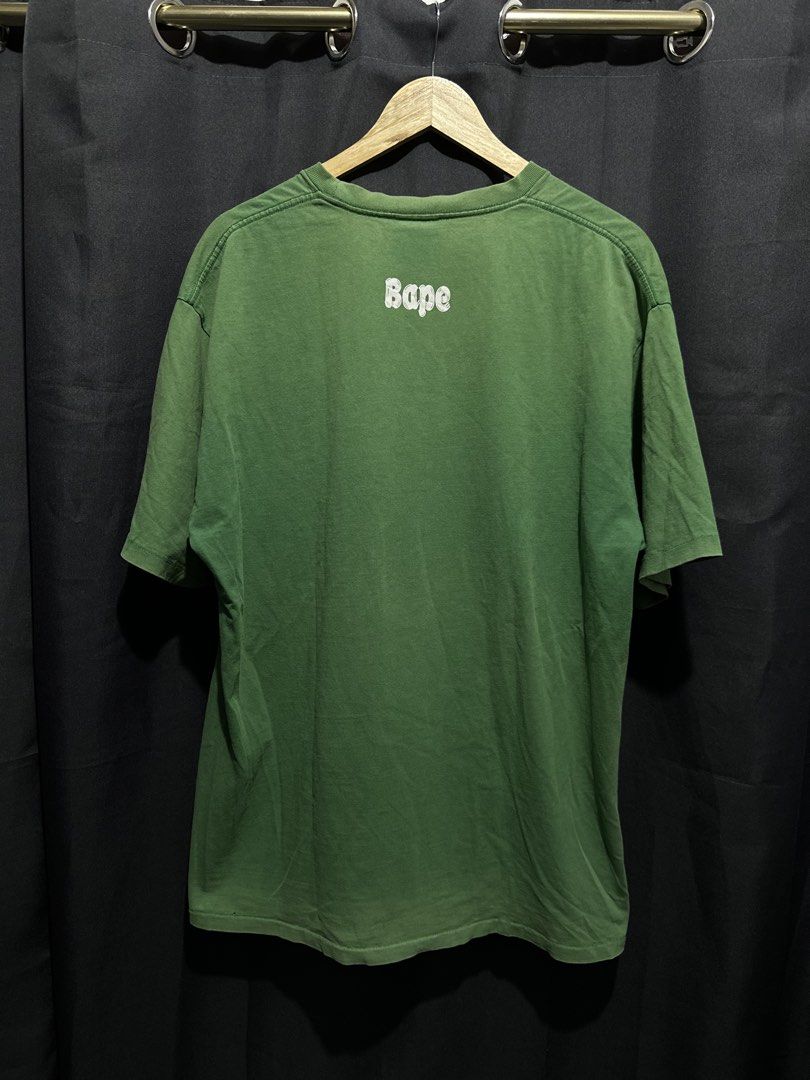BAPE College Ape Head Graphic Tee (Category: Tshirts & Polo Shirts ) located in Buenavista. Submitted by themodernrack (Listing ID 1460887225, Image 2). Description: Brand: A Bathing Ape (BAPE) Color: Green Style: Short Sleeve Graphic Tee (Classic College Ape Head arch logo front print with back neck “Bape” arch graphic) Tag Size: 3XL (Fits approx. 24” x 29”, see measurements) Condition: Good used condition (Repaired small pinhole, minimal light 