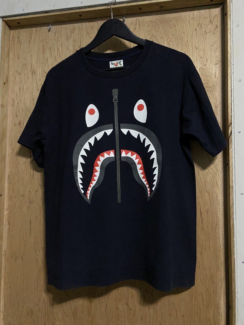 BAPE Shark Face Zip T-Shirt (Category: Tshirts & Polo Shirts ) located in Manila. Submitted by callejage69430 (Listing ID 1460808202, Image 1). Description: 21 width 27 Length Minimal hairline 1 pinhole - Classic BAPE T-shirt - Iconic shark face graphic - Printed zipper detail - Tagged size M - Made in Japan - Ideal for streetwear enthusiasts.