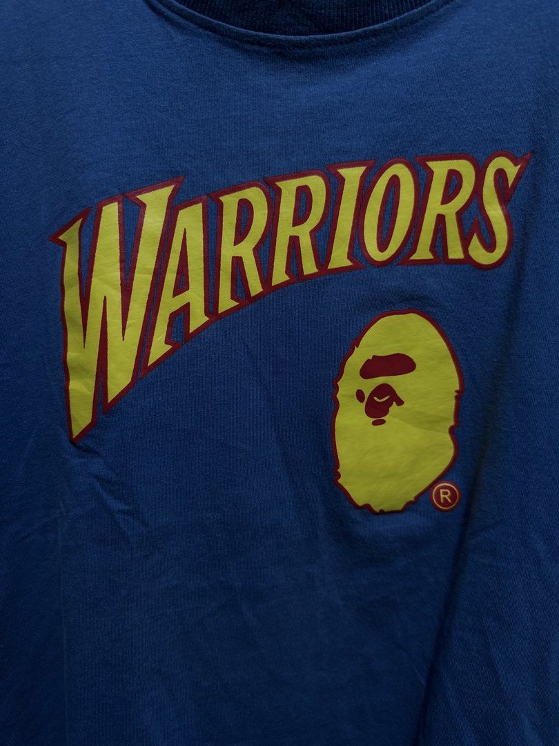 BAPE x Mitchell & Ness NBA Golden State Warriors Tee (Category: Tshirts & Polo Shirts ) located in Buenavista. Submitted by themodernrack (Listing ID 1460894855, Image 3). Description: Brand: A Bathing Ape x Mitchell & Ness Color: Blue Style: Short Sleeve Graphic Tee (Features front Golden State Warriors arch logo with BAPE Ape Head and lower Hardwood Classics jock tag; back printed with “BAPE 93”) Tag Size: XXL (Fits around XL–XXL, see measureme