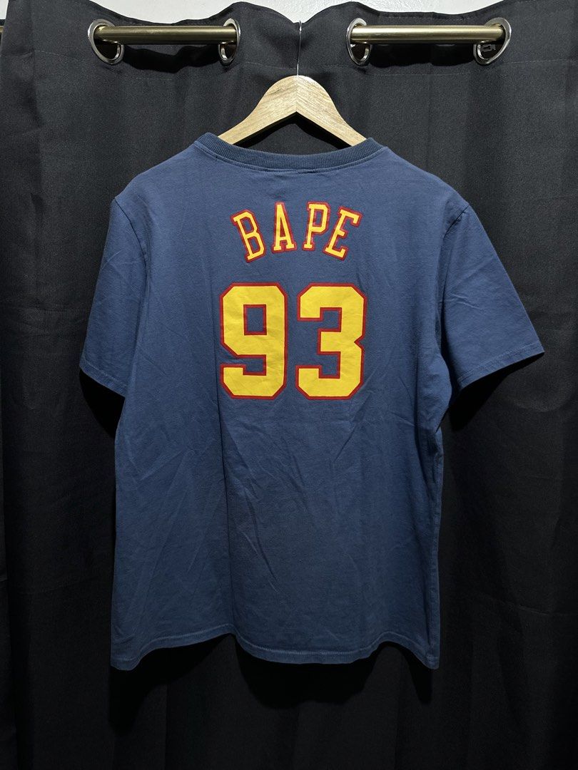 BAPE x Mitchell & Ness NBA Golden State Warriors Tee (Category: Tshirts & Polo Shirts ) located in Buenavista. Submitted by themodernrack (Listing ID 1460894855, Image 2). Description: Brand: A Bathing Ape x Mitchell & Ness Color: Blue Style: Short Sleeve Graphic Tee (Features front Golden State Warriors arch logo with BAPE Ape Head and lower Hardwood Classics jock tag; back printed with “BAPE 93”) Tag Size: XXL (Fits around XL–XXL, see measureme