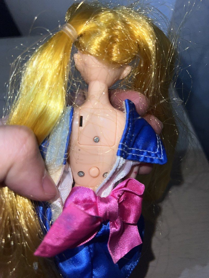 Battery Operated Sailor Moon Doll (Category: Plushies & Soft Toys) located in Manila. Submitted by asa68984 (Listing ID 1460873842, Image 3). Description: - Battery Operated Sailor Moon doll with blonde hair - Iconic sailor uniform with pink bow and blue skirt - Minor marks on chest - Hair is a bit messy - Features a compartment on the back - Ideal for Sailor Moon collectors and fans.