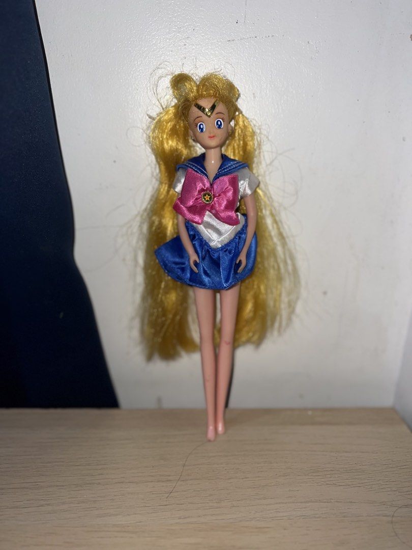 Battery Operated Sailor Moon Doll (Category: Plushies & Soft Toys) located in Manila. Submitted by asa68984 (Listing ID 1460873842, Image 1). Description: - Battery Operated Sailor Moon doll with blonde hair - Iconic sailor uniform with pink bow and blue skirt - Minor marks on chest - Hair is a bit messy - Features a compartment on the back - Ideal for Sailor Moon collectors and fans.