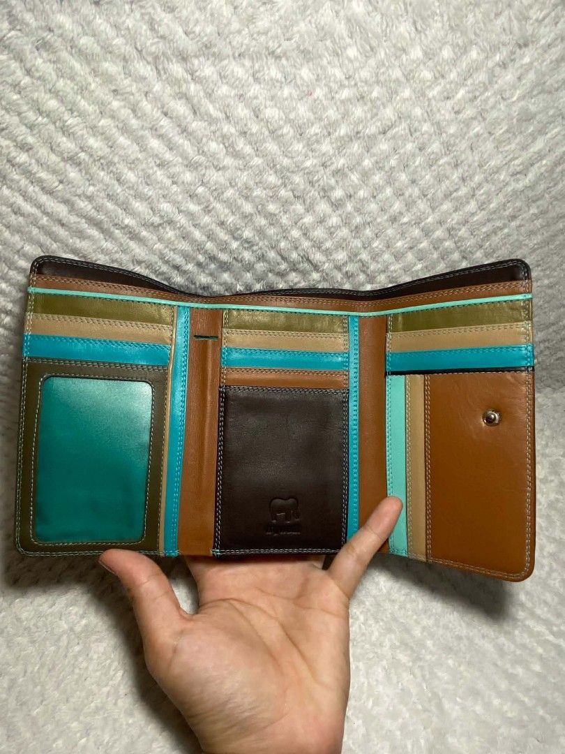 Bifold Leather Wallet (Category: Wallets & Card holders) located in Baguio. Submitted by leah_rodrigo (Listing ID 1460758763, Image 3). Description: - Genuine brown and tan leather bifold wallet - Multiple card slots and compartments for superior organization - Unique small turquoise accent on the zipper pull - Perfect for keeping your essentials tidy - Approximate dimensions when closed: 7 inches x 4 inches.