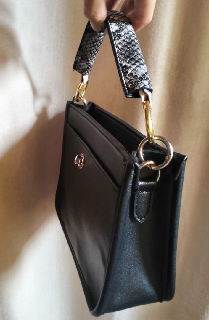 Black Handbag with Snake Print Handle (Category: Luxury Bags & Wallets) located in Caloocan City. Submitted by pretaporter.2026 (Listing ID 1460769467, Image 3). Description: - Unique snake print handle - Gold hardware details - Small front pocket with clasp closure - Ideal for carrying essentials - Versatile style for casual or evening wear -ONCE NAGAMIT, Date Night -Hand Carry Bag (No Strap).