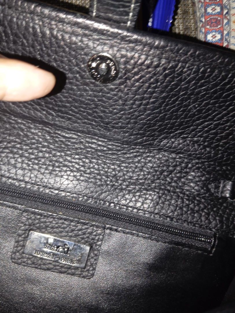 Black Leather Handbag with 'H' Logo (Category: Luxury Bags & Wallets) located in Taguig. Submitted by mavicbien054701 (Listing ID 1460877568, Image 3). Description: - Elegant black leather handbag - Features a prominent 'H' logo on the front flap - Secure magnetic snap closure - Convenient interior zipper pocket - Stylish silver-tone hardware - Adjustable strap for comfortable wear - Exquisitely made in Paris.