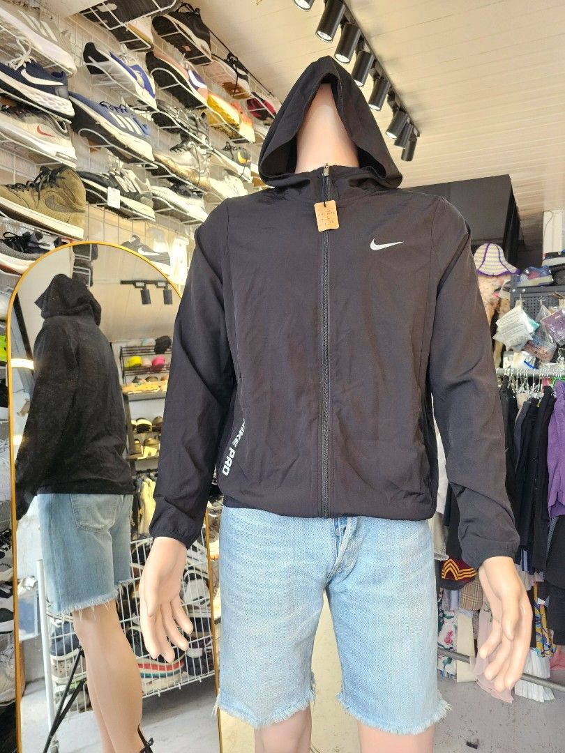black Nike hooded windbreaker jacket (Category: Coats, Jackets and Outerwear) located in Baguio. Submitted by kayeonlineshop (Listing ID 1460798935, Image 1). Description: -black Nike hooded windbreaker jacket featuring a white Swoosh logo on the chest and contrasting "NIKE PRO" text along the lower right hem -measurements included in the photos.