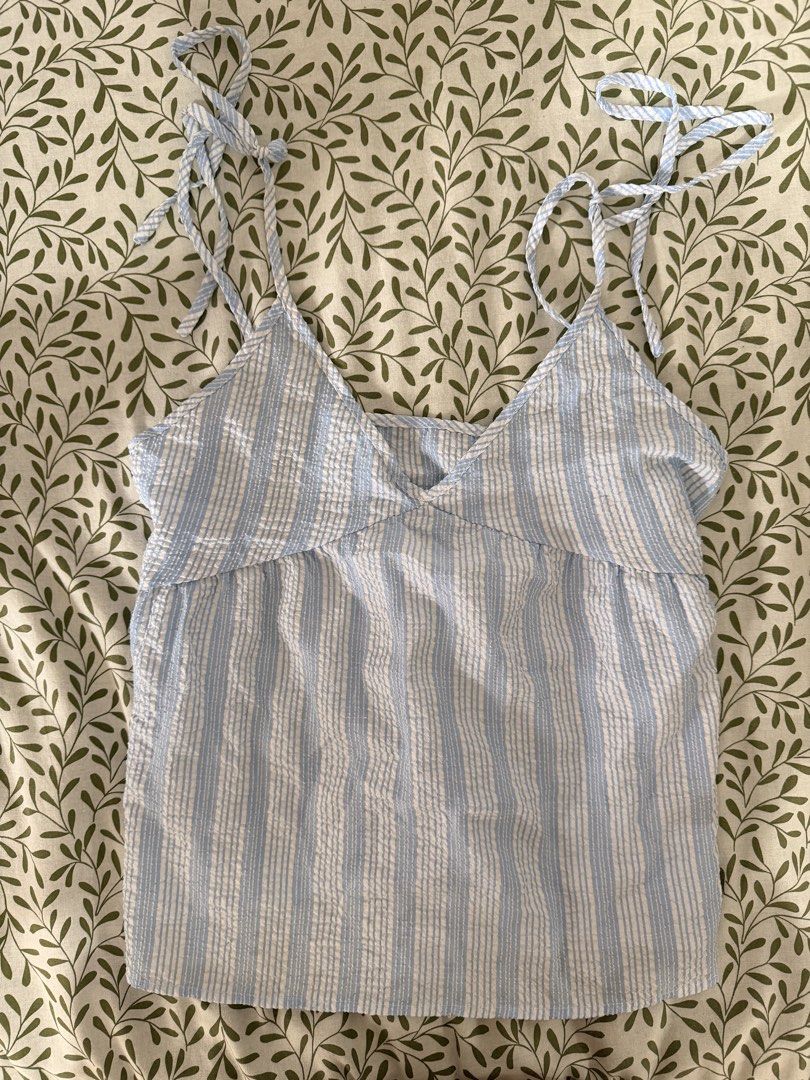 Blue and White Striped Tie-Strap Tank Top (Category: Sleeveless) located in Manila. Submitted by ynasbr (Listing ID 1460789122, Image 1). Description: - Adorable blue and white striped tank top - Features adjustable tie straps on shoulders - Made from lightweight seersucker fabric, ideal for warm weather - Versatile piece, pairs well with shorts or jeans.