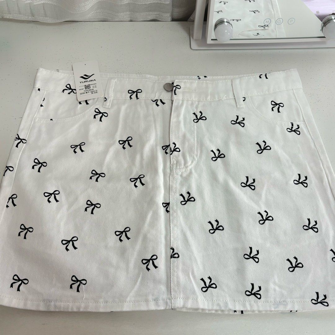 BRAND NEW RIBBON SKIRT (Category: Skirts) located in Manila. Submitted by lexiedeclutters (Listing ID 1460762296, Image 1). Description: - waistline: up to 38” - Brand new white skirt with tags attached - Features a cute all-over black bow print - Functional front and back pockets - Secure button and zip closure.