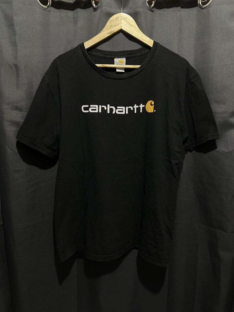 Carhartt Front & Back Core Logo Tee (Category: Tshirts & Polo Shirts ) located in Buenavista. Submitted by themodernrack (Listing ID 1460876123, Image 1). Description: Brand: Carhartt Color: Black Style: Workwear / Streetwear Graphic Tee (Features iconic Carhartt wordmark logo printed on front chest and upper back neck) Tag Size: L (Large) Condition: Good used condition (Light collar fade, minor general fabric wear) Measurements (Inches): Width (