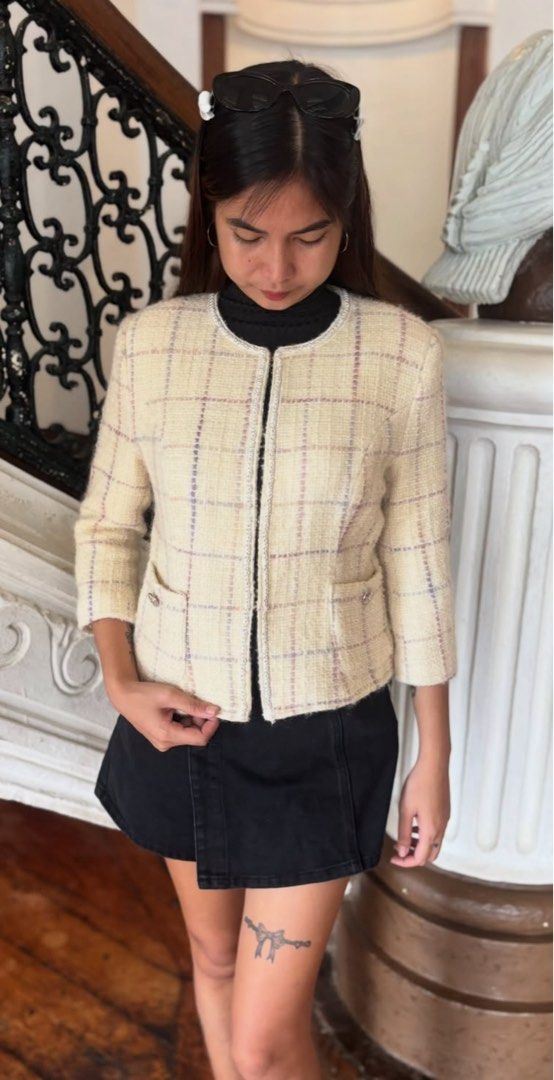 Chanel Tweed Jacket Cream Plaid (Category: Coats, Jackets and Outerwear) located in Alcala. Submitted by dela.sole (Listing ID 1460723614, Image 1). Description: - Authentic Chanel tweed jacket - Elegant plaid pattern with subtle purple and pink threads - Flattering cropped length - Stylish 3/4 sleeves - Two functional front pockets with button details - Smooth, comfortable lined interior - Versatile piece for effortless layering.