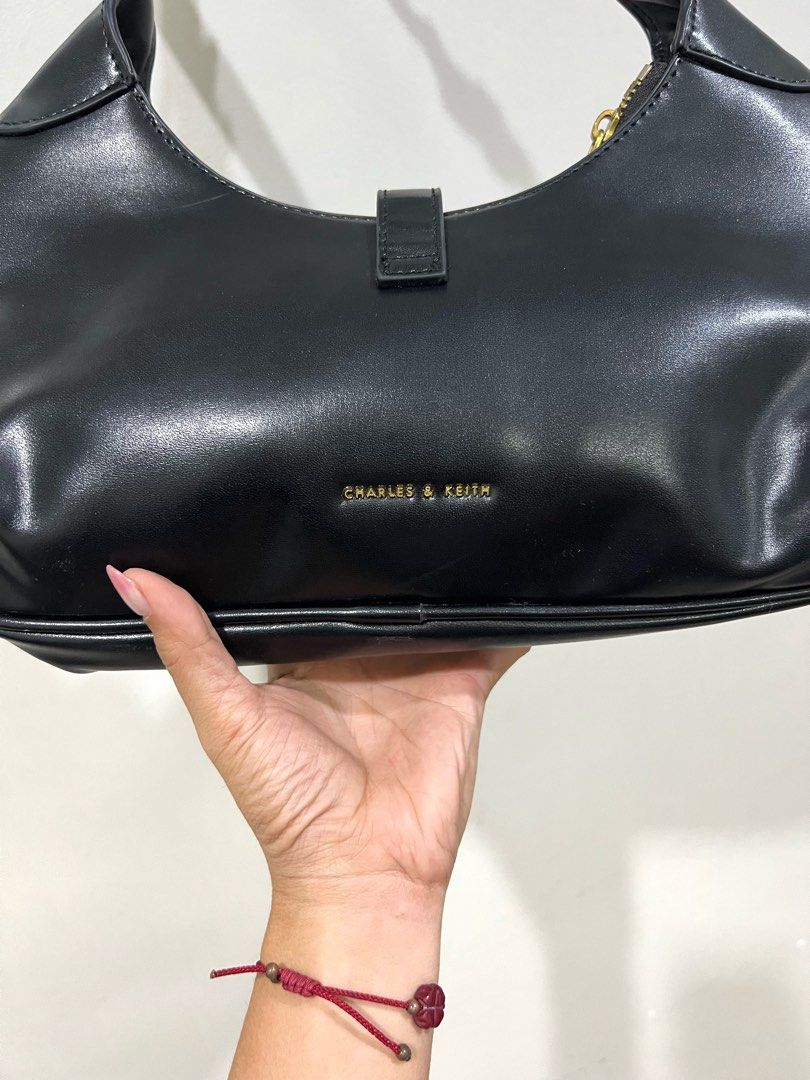 Charles & Keith Black Shoulder Bag with Gold Hardware (Category: Shoulder Bags) located in Digos. Submitted by kathydiane76376 (Listing ID 1460770332, Image 2). Description: - Brand: Charles & Keith - Color: Black - Feature: Gold buckle detail on the front - Closure: Zipper - Strap: Adjustable - Style: Classic and versatile - Occasion: Ideal for everyday use or nights out.