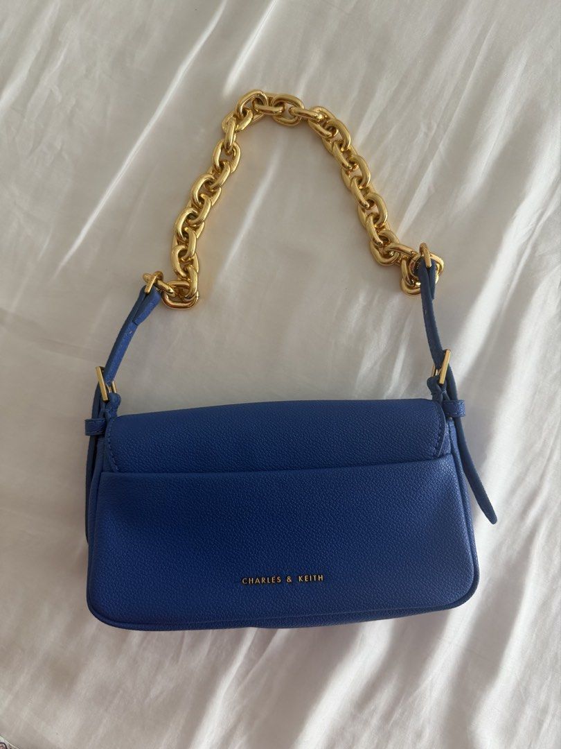 Charles & Keith Blue Shoulder Bag (Category: Shoulder Bags) located in Pasig City. Submitted by angelcstlln (Listing ID 1460737593, Image 2). Description: - Brand: Charles & Keith - Strap: Gold chain strap and detachable blue strap - Interior: Spacious for essentials - Versatility: Ideal for both day and night use.