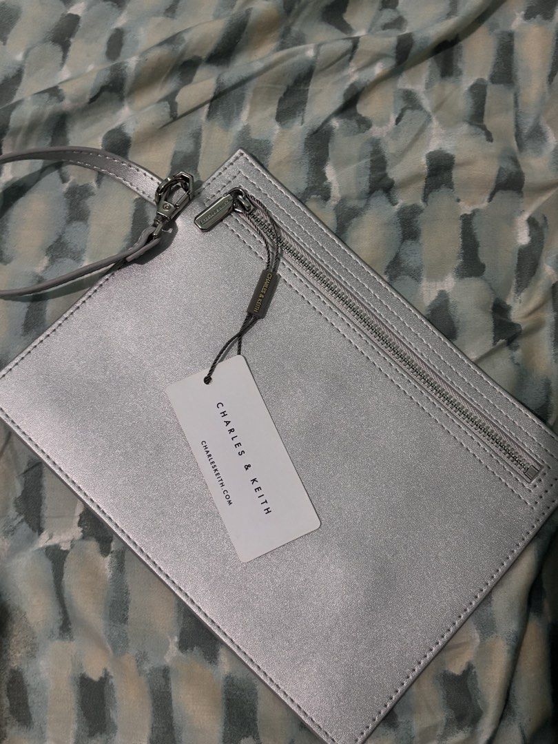 Charles & Keith Silver Metallic Clutch Bag with Tag (Category: Clutches) located in La Trinidad. Submitted by caicai1926 (Listing ID 1460808829, Image 1). Description: - Brand: Charles & Keith - Color: Silver Metallic - Condition: Brand new with original tag attached - Closure: Zip closure - Style: Simple, sleek clutch - Occasion: Ideal for evenings out or adding a touch of shine to your look.