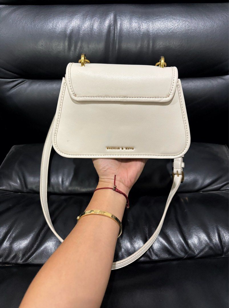 Charles & Keith White Handbag with Gold Hardware (Category: Luxury Bags & Wallets) located in Digos. Submitted by kathydiane76376 (Listing ID 1460741369, Image 2). Description: - Brand: Charles & Keith - Color: White - Hardware: Gold details (ring on front flap, chain strap) - Interior: Main compartment, inner zip pocket, clean interior - Style: Versatile, suitable for everyday or special occasions.