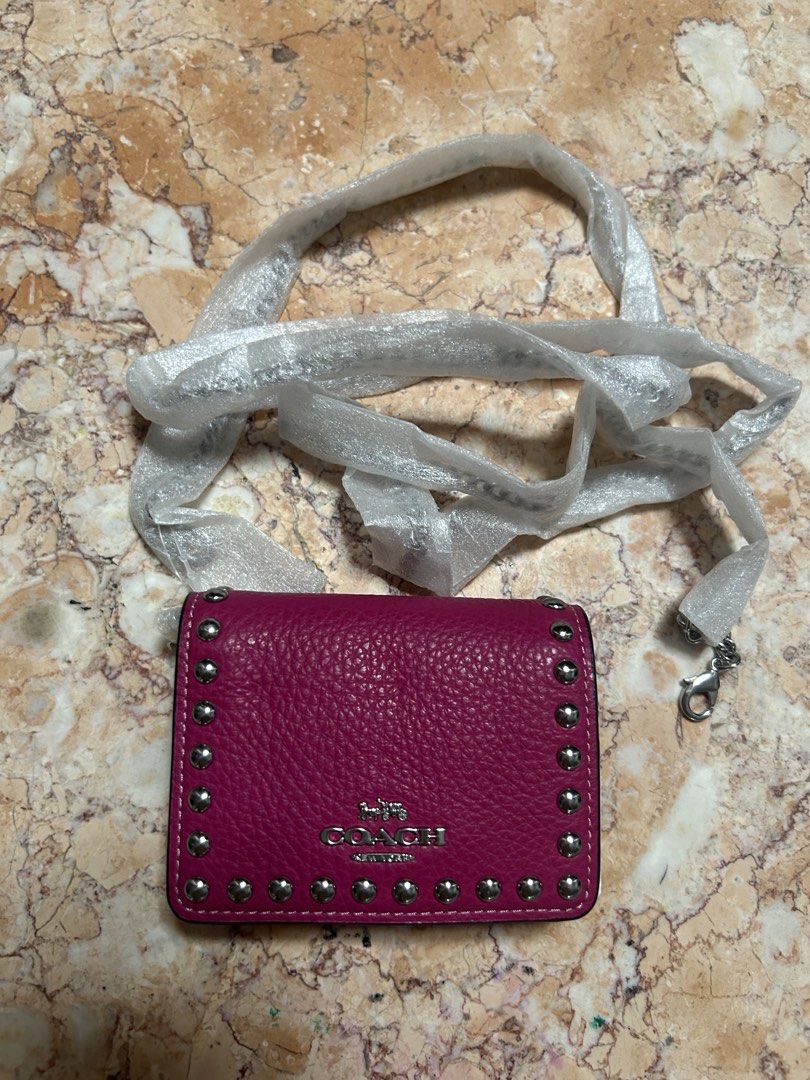 Coach Mini Wallet on Sling (Category: Wallets & Card holders) located in Bacoor. Submitted by iamgraxa (Listing ID 1460716884, Image 1). Description: - Coach pink pebbled leather wallet - Stylish studded detailing around the edges - Comes with a detachable strap and clasp - Compact and perfect for carrying your essentials.