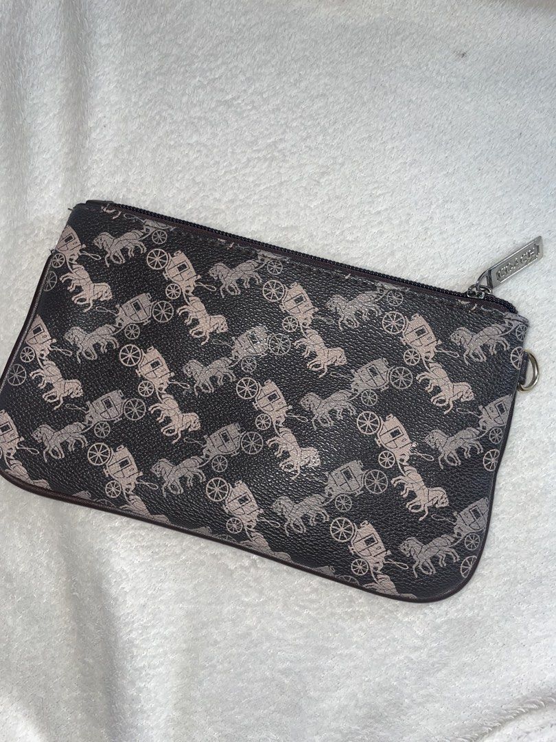 Coach Pouch (Category: Luxury Bags & Wallets) located in Bulacan. Submitted by keytxcx (Listing ID 1460879377, Image 2). Description: - Coach pouch with signature horse and carriage print - Interior lining features Coach 'C' pattern - Secure zipper closure - Lost wrist strap - Ideal for organizing essentials or carrying solo - Preloved - No box or dustbag - Price is still negotiable!!! - With freebies - RFS: decluttering - Dm me for more Inquiry 