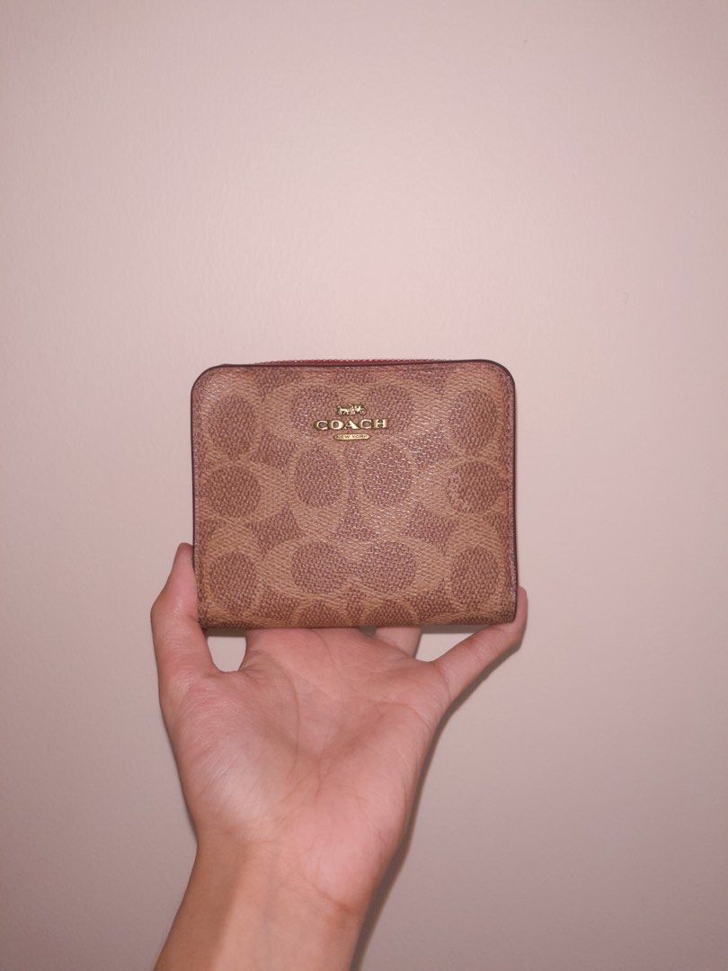 Coach Signature Canvas Zip Around Wallet (Category: Wallets & Card holders) located in Angeles City. Submitted by accountnameundecided (Listing ID 1460749508, Image 3). Description: - Authentic Coach wallet - Signature C pattern in tan and brown canvas - Vibrant red interior - Zip-around closure with red leather pull tab - Compact and pocket-friendly design - Ideal for cards and coins 🚚 Shipping: via Lalamove Shipping Fee: shouldered by buyer Mo