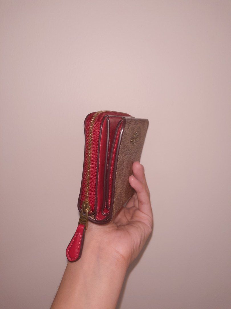 Coach Signature Canvas Zip Around Wallet (Category: Wallets & Card holders) located in Angeles City. Submitted by accountnameundecided (Listing ID 1460749508, Image 2). Description: - Authentic Coach wallet - Signature C pattern in tan and brown canvas - Vibrant red interior - Zip-around closure with red leather pull tab - Compact and pocket-friendly design - Ideal for cards and coins 🚚 Shipping: via Lalamove Shipping Fee: shouldered by buyer Mo