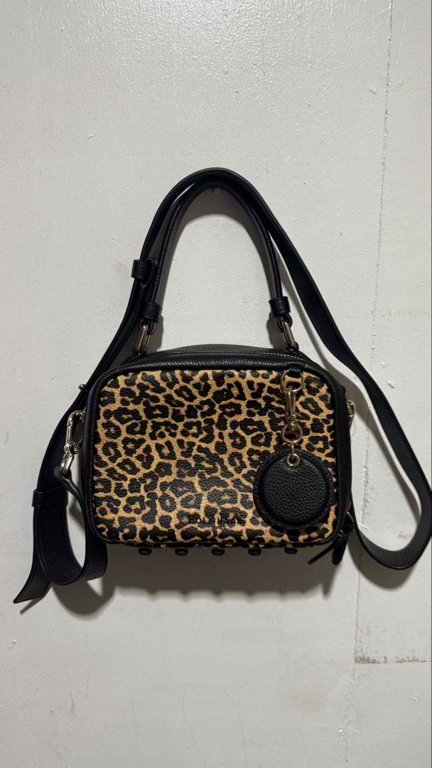 Cole Haan Mini Boston Bag (Category: Cross-body Bags) located in Binan City. Submitted by allyson__ (Listing ID 1460878384, Image 1). Description: - Cute Cole Haan crossbody bag - Fun leopard print on the front - Black leather details - Gold hardware with stud accents - Grey interior with zippered pocket - Adjustable strap for comfortable wear - Great for everyday use.