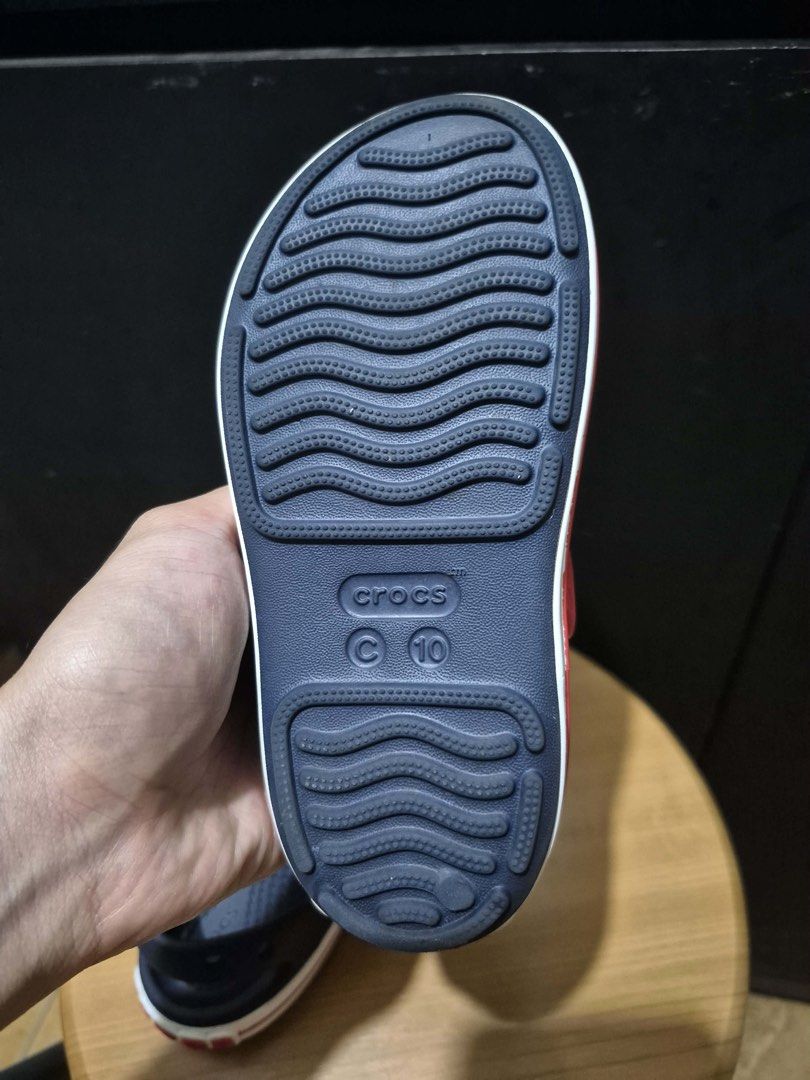 Crocs Kids Sandals Size C10 Navy Red (Category: Babies & Kids Fashion) located in Paranaque City. Submitted by VGDECLUTTERS (Listing ID 1460919201, Image 3). Description: - Navy blue Crocs sandals for kids - Red straps across the top - Easy slip-on style - Classic Crocs wavy sole pattern for grip - Size C10 - Ideal for everyday wear or beach outings.