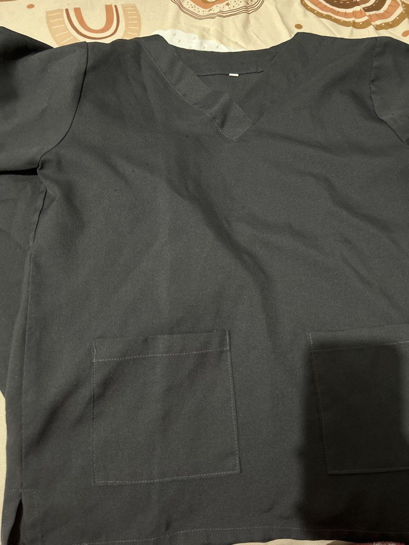 Dark Grey V-Neck Scrub Top with Pockets (Category: Others Tops) located in Manila. Submitted by kitkatchew (Listing ID 1460846911, Image 1). Description: - Dark grey V-neck scrub top - Short sleeves - Two convenient front pockets - Simple and functional design - Ideal for work or casual wear - Easy to wash and maintain.