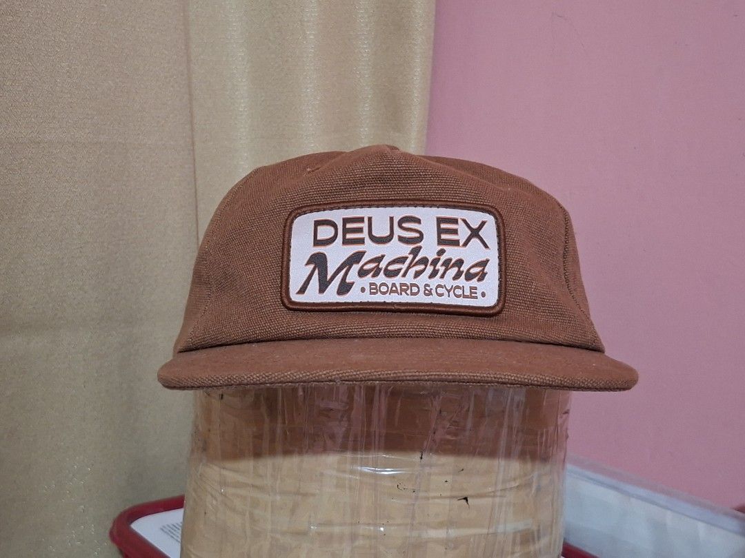 Deus Ex Machina Board & Cycle Cap Brown (Category: Caps & Hats) located in Cagayan de Oro. Submitted by ohh-kay (Listing ID 1460769051, Image 1). Description: - Brand: Deus Ex Machina - Features iconic 'Deus Ex Machina Board & Cycle' logo on the front - Deus branding also present on the back and inside the cap - Adjustable strap for a customized fit - Perfect for everyday casual wear - Prelove both this brand new 1 year ago.