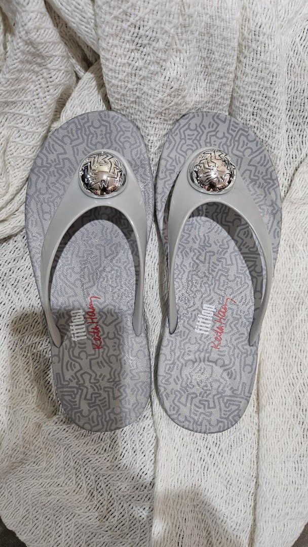 Fitflop x Keith Haring Silver Flip Flops US 6 (Category: Slippers and slides) located in Manila. Submitted by lilmissangeline (Listing ID 1460781551, Image 1). Description: - Grey Fitflop flip flops - Features unique Keith Haring artwork - Size: US 6 / EU 37 - Includes original box - Brand New - Never used - Ideal for everyday casual wear RFS: gift from the brand but wrong size, sadly.