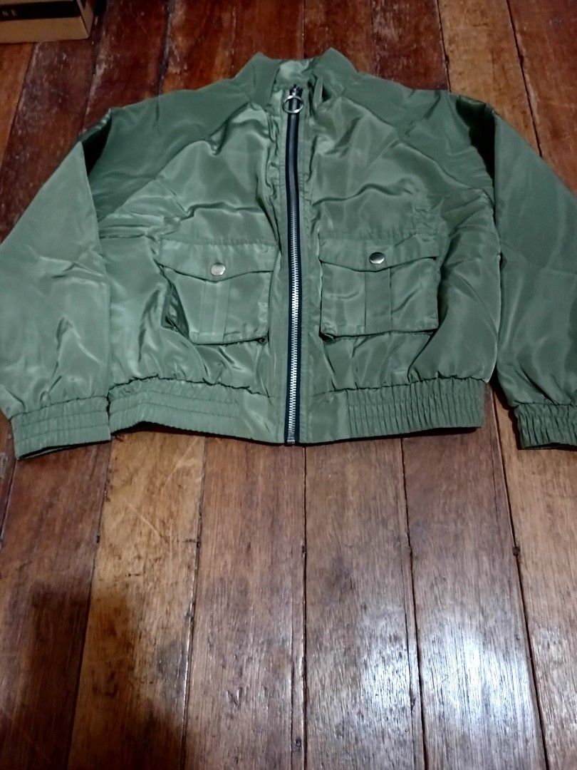 Forever 21 Girls Green Bomber Jacket (Category: Coats, Jackets and Outerwear) located in Manila. Submitted by luckyeagle-7ff8 (Listing ID 1460746319, Image 2). Description: - Forever 21 green bomber jacket - Soft, fuzzy white lining for warmth - Two front pockets with button closures - Ribbed cuffs and hem for a snug fit - Ideal for cooler weather.