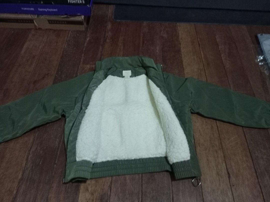 Forever 21 Girls Green Bomber Jacket (Category: Coats, Jackets and Outerwear) located in Manila. Submitted by luckyeagle-7ff8 (Listing ID 1460746319, Image 3). Description: - Forever 21 green bomber jacket - Soft, fuzzy white lining for warmth - Two front pockets with button closures - Ribbed cuffs and hem for a snug fit - Ideal for cooler weather.