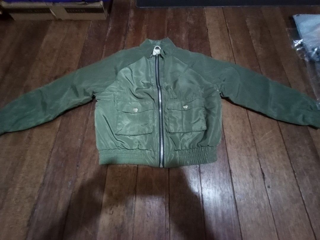 Forever 21 Girls Green Bomber Jacket (Category: Coats, Jackets and Outerwear) located in Manila. Submitted by luckyeagle-7ff8 (Listing ID 1460746319, Image 1). Description: - Forever 21 green bomber jacket - Soft, fuzzy white lining for warmth - Two front pockets with button closures - Ribbed cuffs and hem for a snug fit - Ideal for cooler weather.