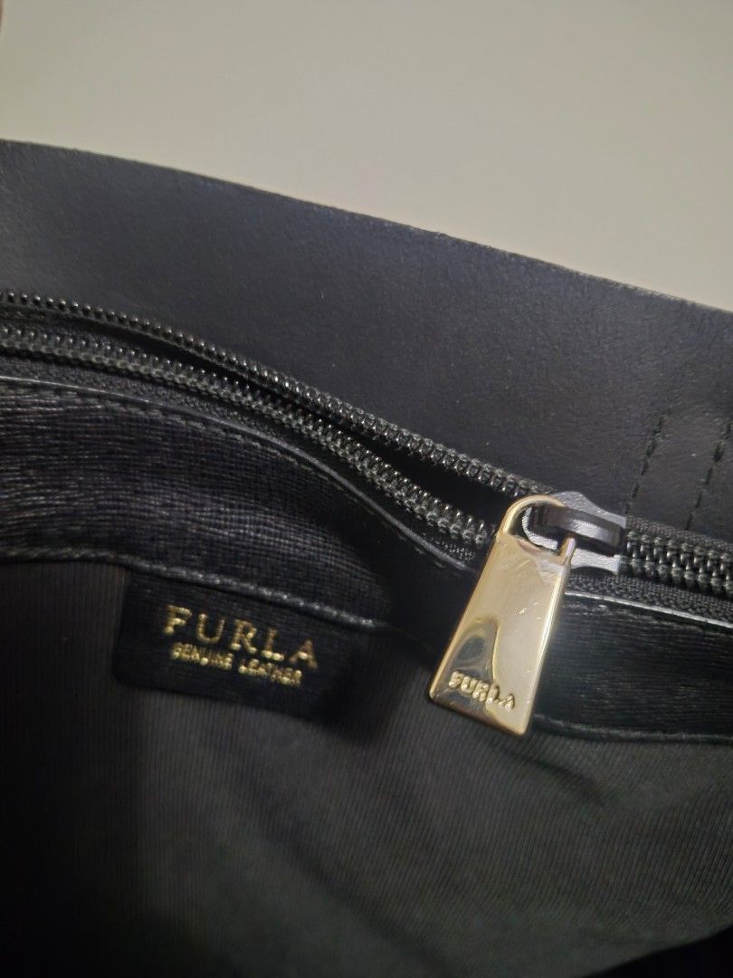 Furla Black Leather Tote Bag - OG (Category: Luxury Bags & Wallets) located in Alaminos. Submitted by tindahanicera (Listing ID 1460772000, Image 3). Description: - Classic black Furla tote bag - Textured leather exterior - Elegant gold hardware (logo charm, zipper pull) - Roomy interior for essentials - Ideal for everyday or travel H - 10.5 in L - 12 in (bottom) 17in (top) W - 6 in Handle - 18 in.