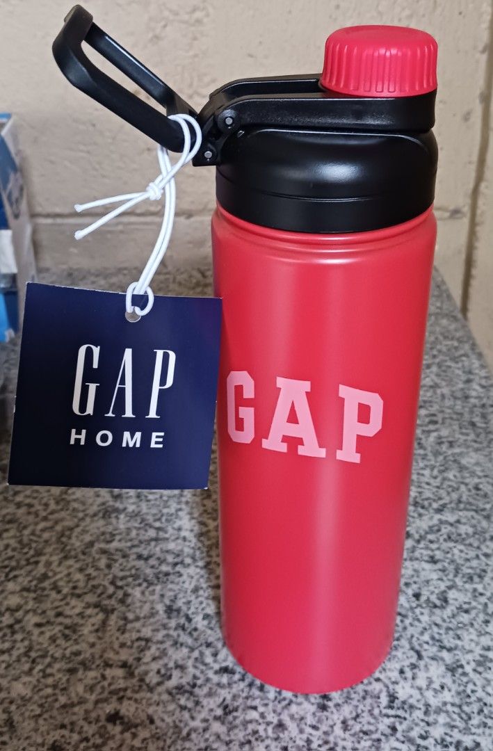 GAP Home Red Water Bottle (Category: Water Bottles & Tumblers) located in Cainta. Submitted by karlaangel32149 (Listing ID 1460790628, Image 2). Description: - Red water bottle from GAP Home - Black flip-top lid with red screw-on cap - Includes a black carrying handle - Features the GAP logo printed on the front - Ideal for staying hydrated while traveling or during activities.