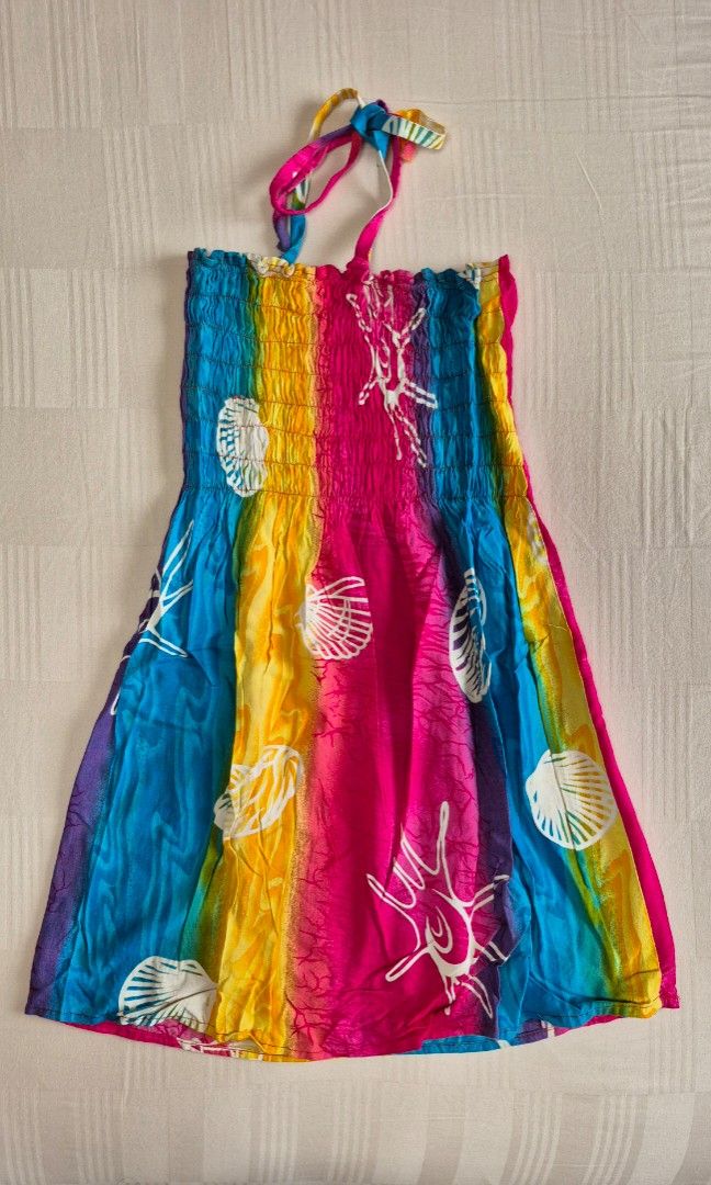 Girls Summer Dress (Category: Babies & Kids Fashion) located in Quezon City. Submitted by akcstuff (Listing ID 1460745122, Image 1). Description: - Fun and colorful tie-dye dress - Features a rainbow gradient with white shell and starfish prints - Smocked bodice for a comfortable and flattering fit - Halter neck with adjustable tie - Lightweight fabric, ideal for beach days or casual outings.