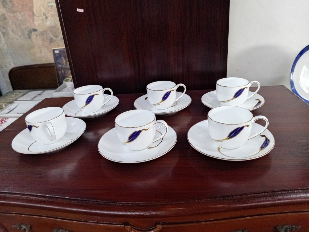 Givenchy Coffee Cups and Saucers Set (Category: Coffee & Tea Tableware) located in Manila. Submitted by keenhorse.30d35c (Listing ID 1460769755, Image 1). Description: - Set of 6 coffee cups and saucers - Material: White porcelain - Design: Blue leaf pattern with a gold rim - Authentic Givenchy logo on each cup - Perfect for serving coffee or espresso - Adds a touch of luxury to your kitchen - Makes a wonderful gift.