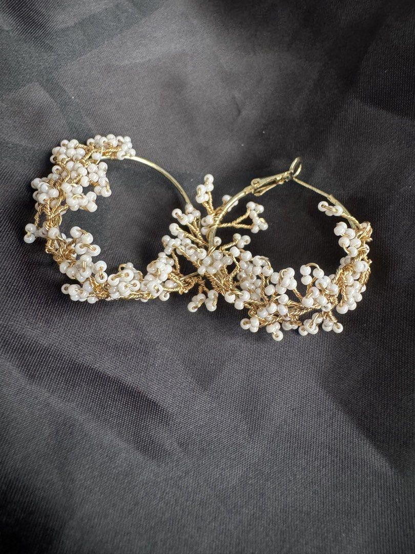 Gold Hoop Earrings with White Beads (Category: Earrings) located in Angeles City. Submitted by thala.1204.68 (Listing ID 1460743741, Image 1). Description: - Chic gold hoop earrings - Adorned with small white beads clustered to resemble flowers or berries - Intricate gold wire detailing - Secure and reliable clasp closure - Versatile accessory: elevates both casual and formal outfits - Adds a touch of flair and elegance to any look.
