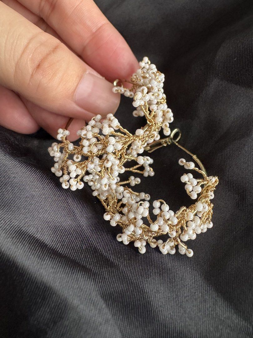 Gold Hoop Earrings with White Beads (Category: Earrings) located in Angeles City. Submitted by thala.1204.68 (Listing ID 1460743741, Image 2). Description: - Chic gold hoop earrings - Adorned with small white beads clustered to resemble flowers or berries - Intricate gold wire detailing - Secure and reliable clasp closure - Versatile accessory: elevates both casual and formal outfits - Adds a touch of flair and elegance to any look.