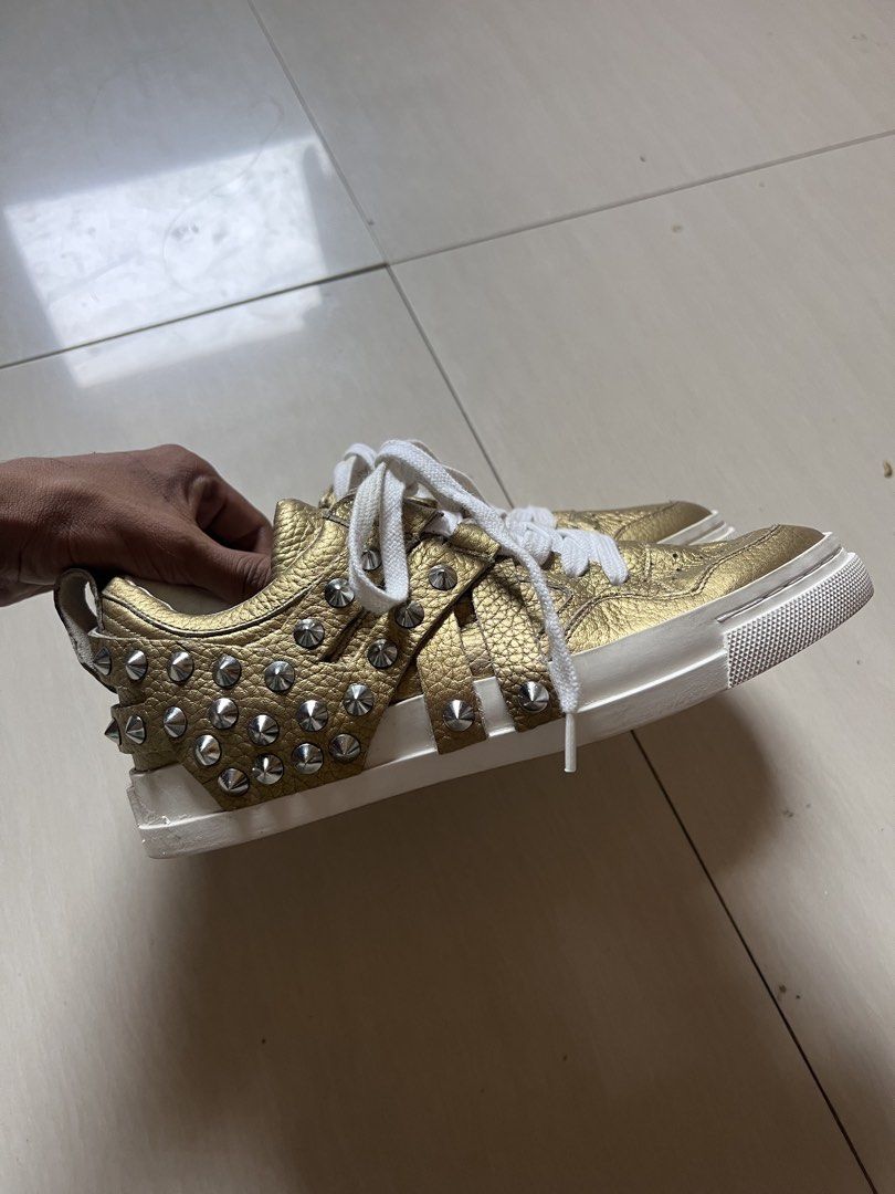 Gold Studded Sneakers with White Laces ash (Category: Sneakers) located in Zamboanga. Submitted by safe.haimer (Listing ID 1460840265, Image 2). Description: - Eye-catching gold sneakers - Adorned with silver studs all around - Features crisp white laces - Unique wavy sole pattern for a distinctive look - Size: 37 - Ideal for making a bold fashion statement.