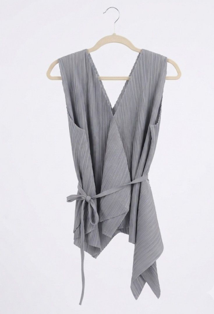 Grey Pleated Wrap Top with Tie Belt (Category: Sleeveless) located in Donsol. Submitted by saksthriftavenuebyluckymaria8 (Listing ID 1460840439, Image 2). Description: - Sleeveless grey top - Flattering V-neckline - Chic wrap-around design - Includes matching waist tie belt - Unique pleat fabric detail - Versatile: pairs well with trousers or Skirts length 22in assymetrical.