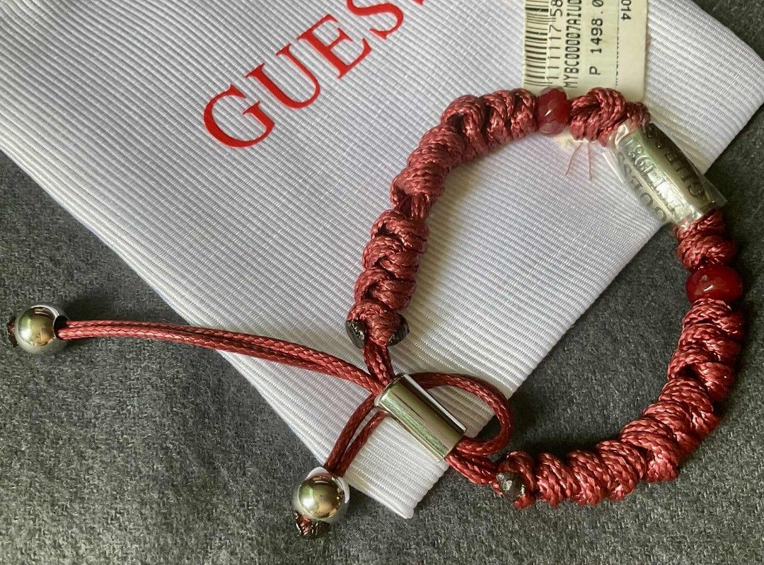 Guess Red Cord Bracelet (Category: Luxury Accessories) located in Pasig City. Submitted by peony_princess (Listing ID 1460716647, Image 2). Description: Authentic Guess bracelet. Features a red cord design with a silver-tone Guess logo bead accent. Includes a drawstring pouch and price tag. The bracelet has adjustable sizing. The tag indicates an SRP of 1498.00..