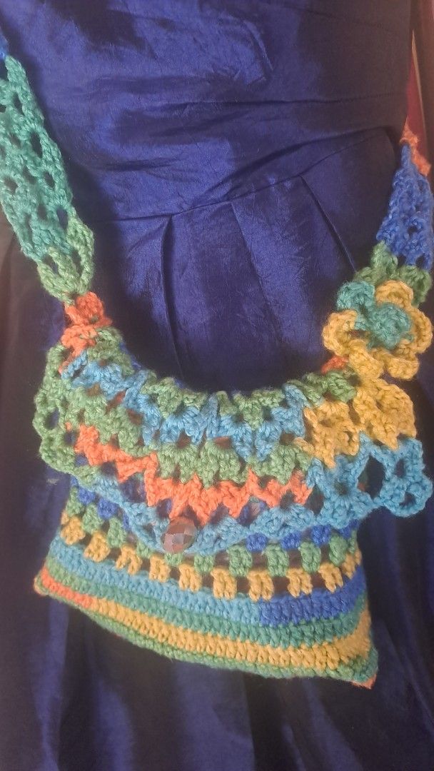 Handmade Crochet Bag with Strap (Category: Shoulder Bags) located in Davao. Submitted by bravemoon_556cd5 (Listing ID 1460858933, Image 2). Description: - Handmade crochet bag - Vibrant granny square pattern (blue, green, orange, yellow) - Long strap for shoulder or crossbody wear - Secure button closure - Unique and eye-catching design - Ideal for casual day outs.