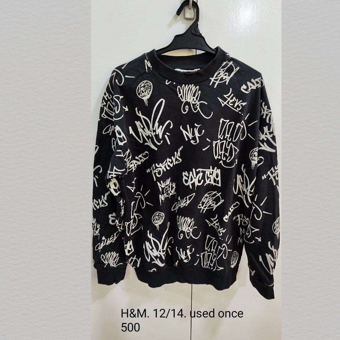 H&M Graffiti Print Sweatshirt (Category: Babies & Kids Fashion) located in Manila. Submitted by little_dees_shop (Listing ID 1460727385, Image 1). Description: - Black sweatshirt with all-over white graffiti print - Size: 12/14 - Perfect for casual wear.